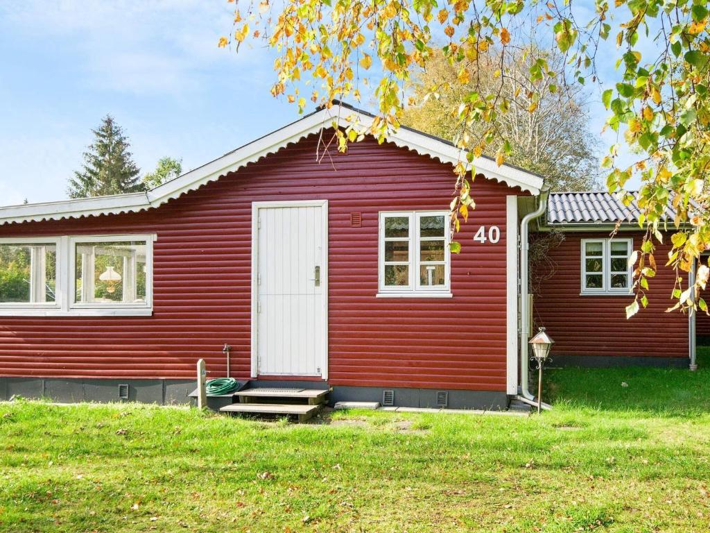 a red house with a white door at 4 person holiday home in Glesborg in Glesborg