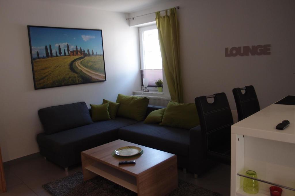 a living room with a blue couch and a table at Ferienlounge in Salzhemmendorf