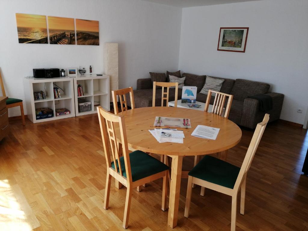una mesa y sillas en una sala de estar con sofá en Wohnung Lemkenhafen, en Fehmarn