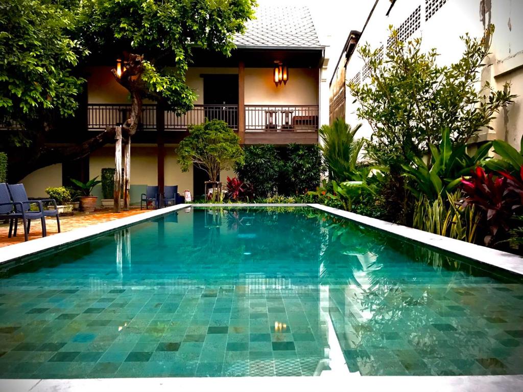 a swimming pool in front of a house at VILLA BANGKOK formerly VILLA PHRA SUMEN in Bangkok