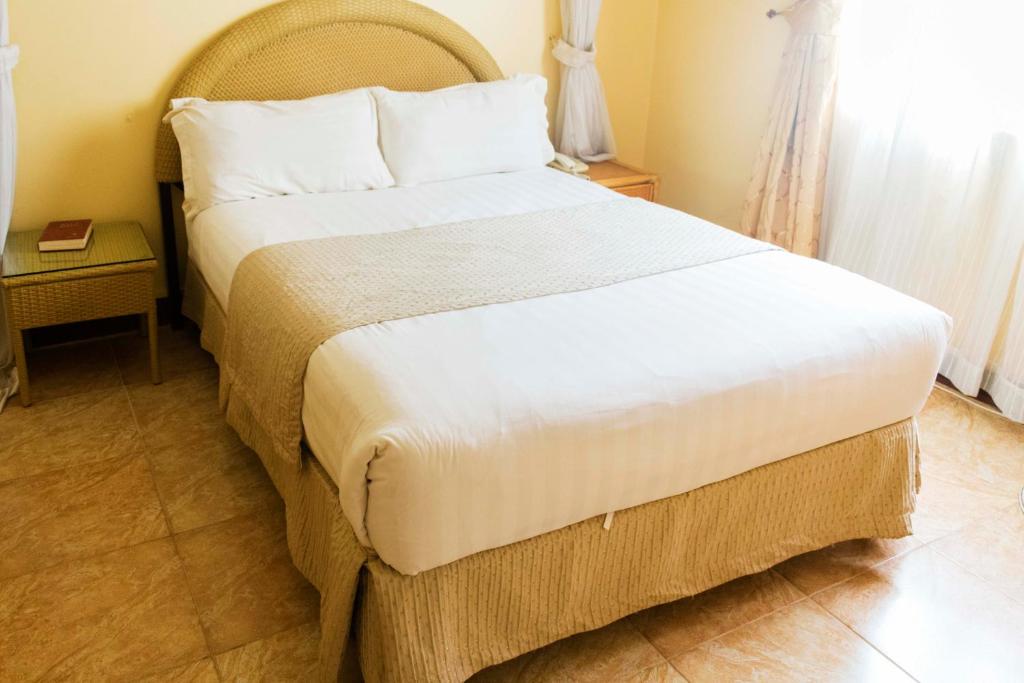 a bedroom with a large bed in a room at Agip Motel Mbarara in Mbarara