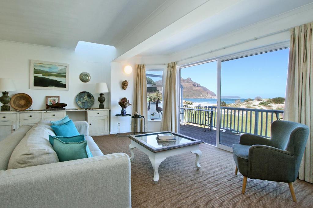 a living room with a couch and a view of the ocean at 6 Jamaica Beach in Hout Bay