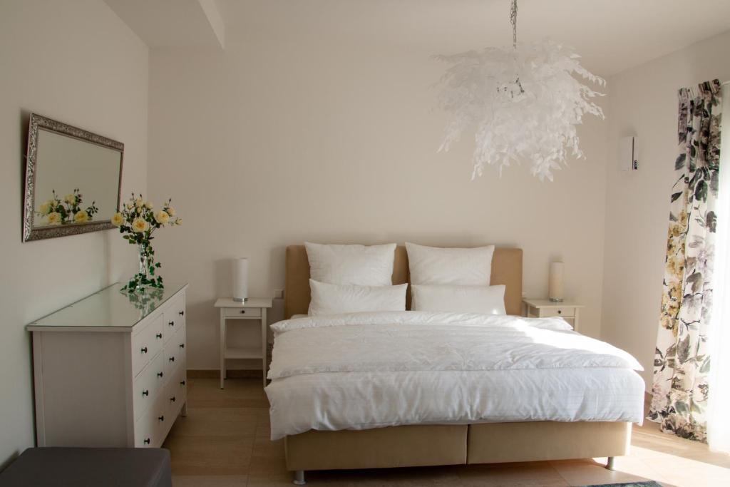 a bedroom with a bed and a dresser and a chandelier at Penthouse Wäschenbeuren in Wäschenbeuren