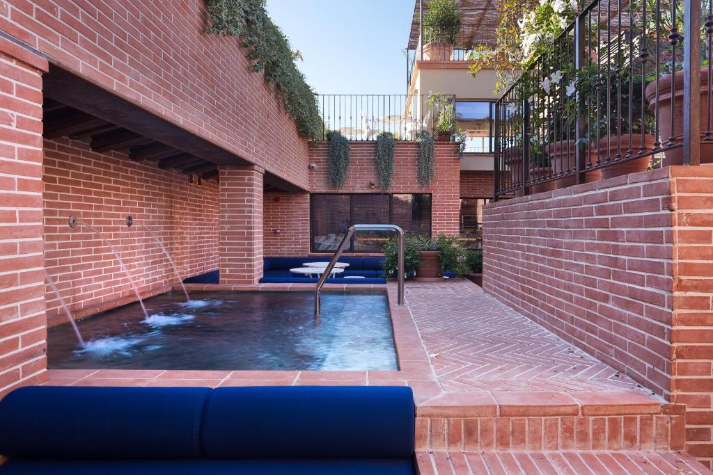 フィレンツェにあるHotel Calimala Florenceのレンガ造りの建物内のスイミングプール