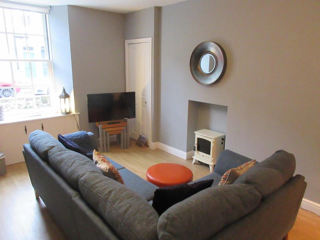 ein Wohnzimmer mit einem Sofa und einem Flachbild-TV in der Unterkunft WEE NEUK in Cellardyke
