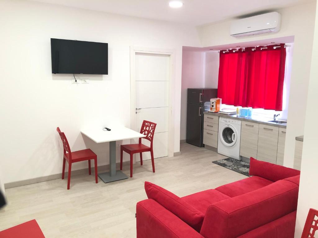 ein Wohnzimmer mit einem roten Sofa und einem Tisch in der Unterkunft Attico Lady D in Paola