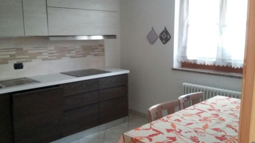 eine Küche mit einer Theke und einem Tisch in der Unterkunft Villetta Muncion in Pozza di Fassa