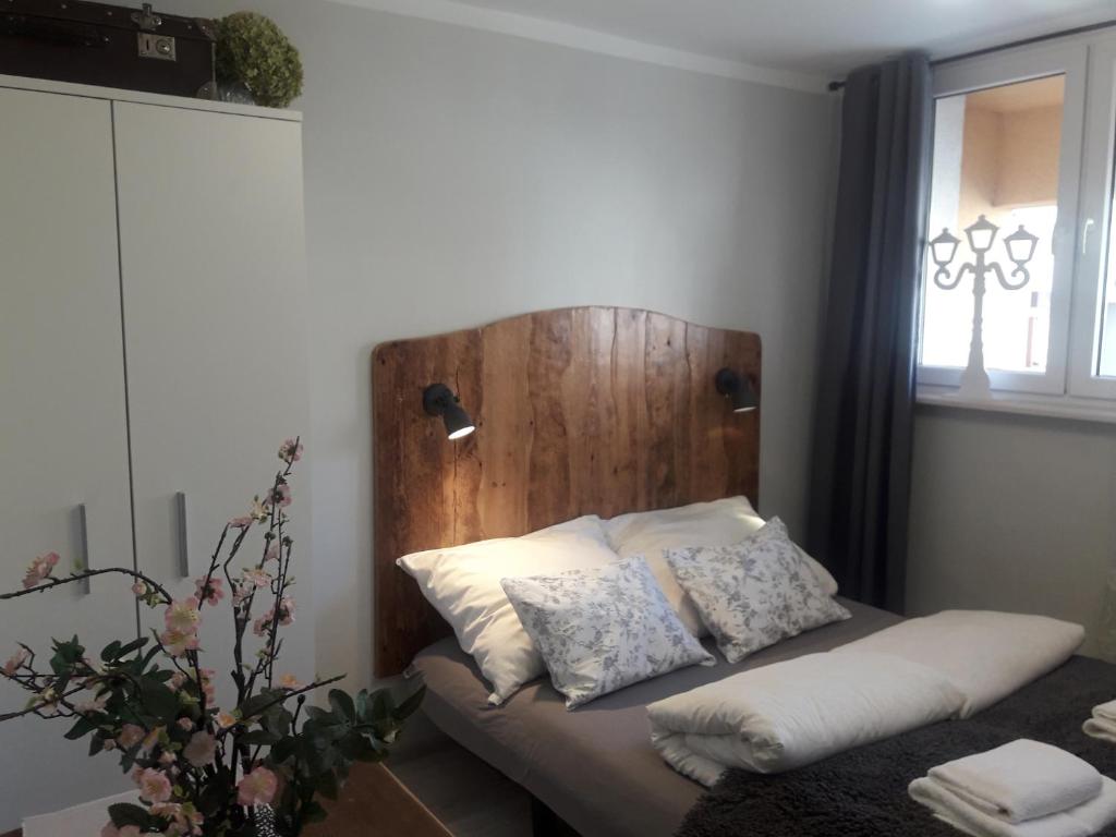 uma cama com uma cabeceira de madeira num quarto em Przy ratuszu em Świebodzin