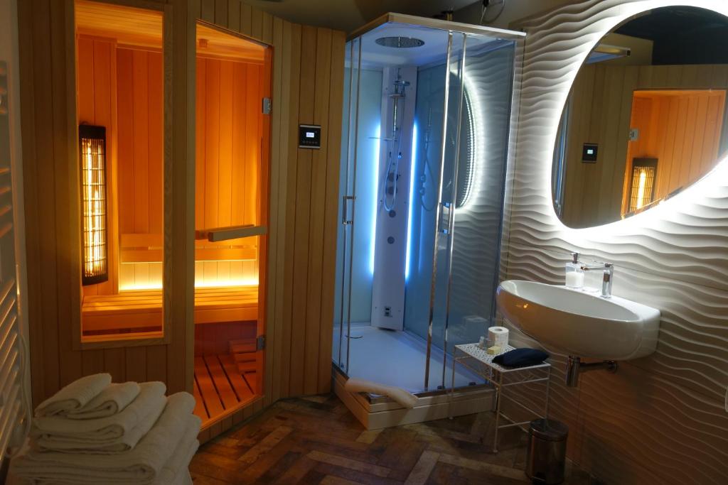 uma casa de banho com um lavatório e um chuveiro com um espelho. em Holiday Homes - mini spa - Nemi (Roma) em Nemi