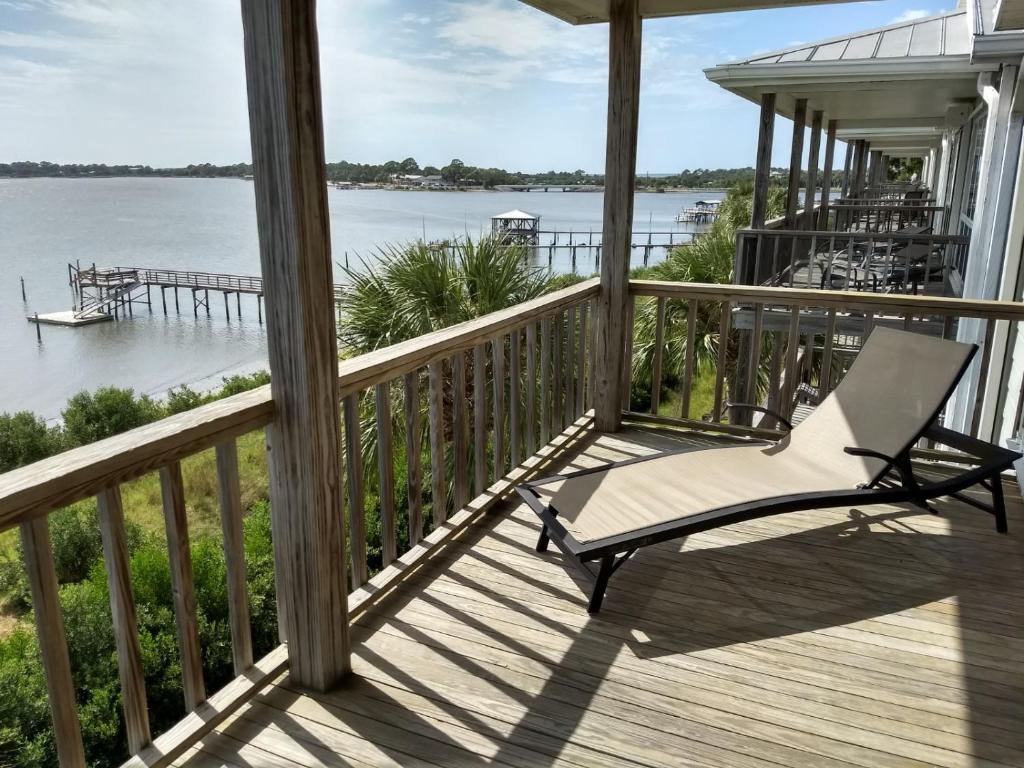 a rocking chair on a porch with a view of the water at Seahorse Landing #503 Gulf Front Vacation Condo in Cedar Key