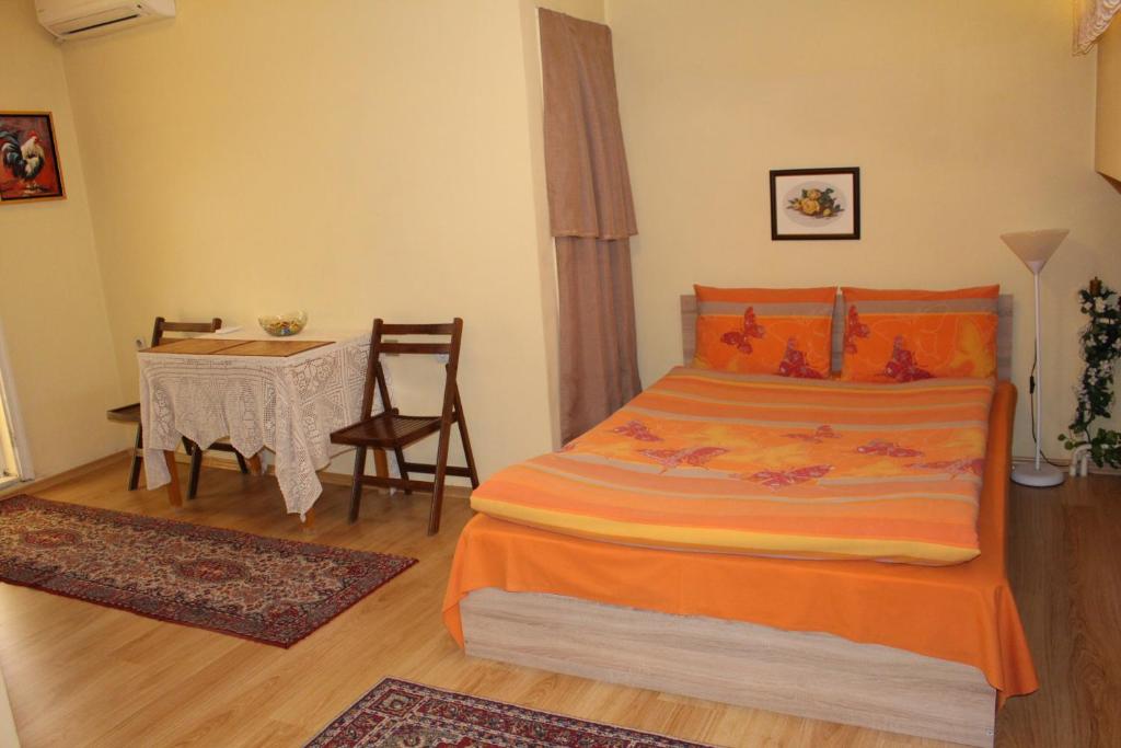 a bedroom with a bed and a table with a chair at Studio Pleven Center in Pleven