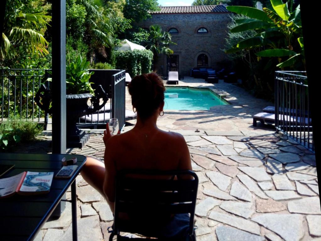 a woman sitting in a chair in front of a pool at 45BB in Carcassonne