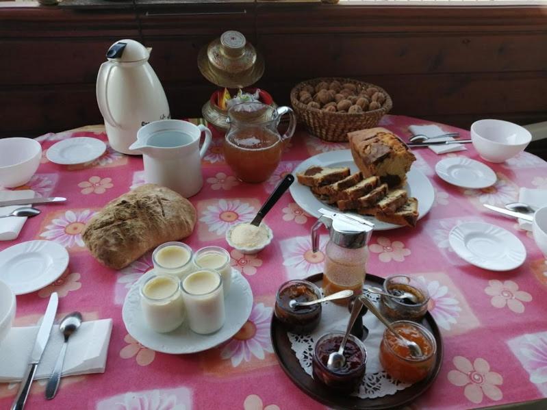 una mesa con un mantel rosa con comida. en Le Fidèle, en Saint-Chamant