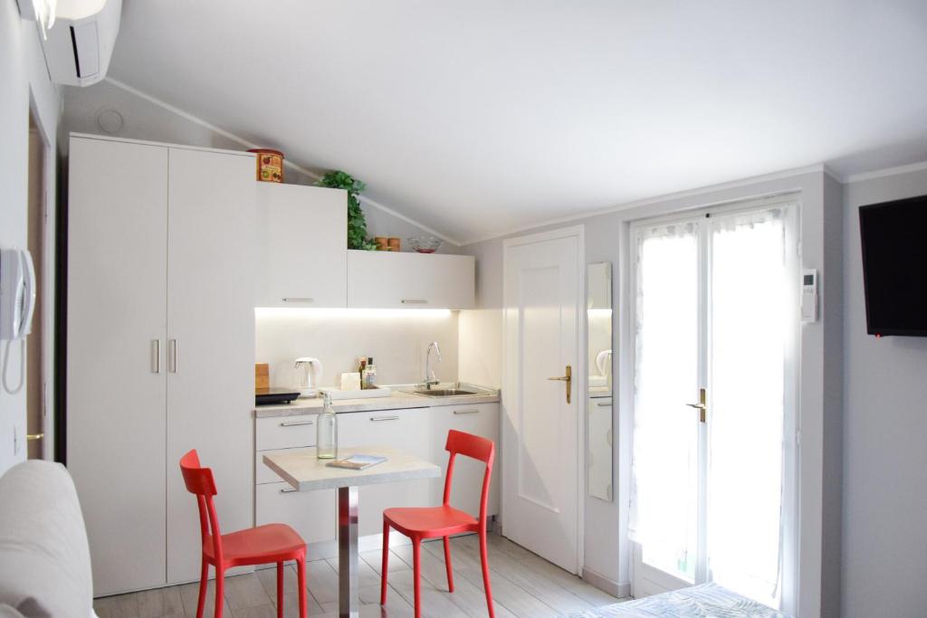 eine kleine Küche mit roten Stühlen und einem Tisch in der Unterkunft Sottoriva dream in Verona
