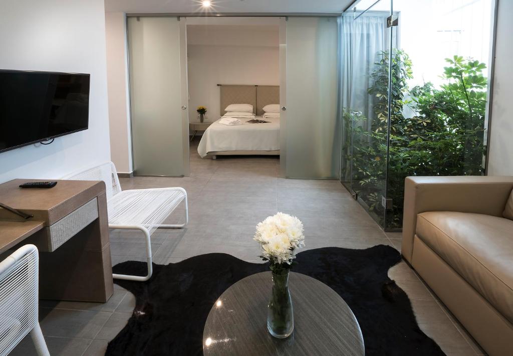 a living room with a couch and a table with flowers at Carolina Hotel since 1934 in Athens