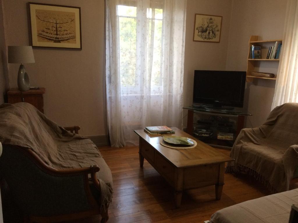 a living room with a coffee table and a tv at Petite maison proche de Montbéliard in Sainte-Suzanne