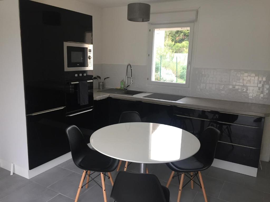 une cuisine avec une table blanche et des appareils noirs dans l'établissement Maison avec Jardin/Piscine - Quartier résidentiel, à Marseille