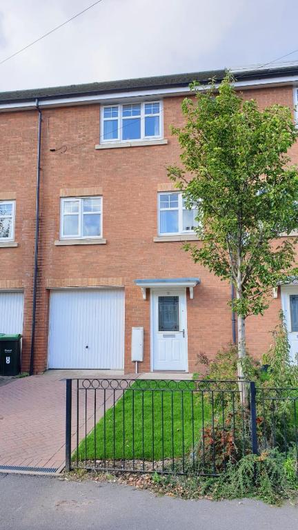 a brick house with two garage doors and a tree at Seymour Road - Parking for van - Contractors only in Oldbury