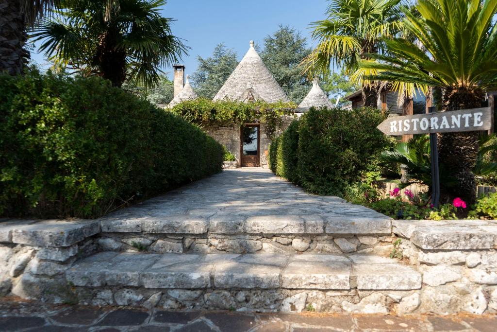 a path to the entrance to a resort with a sign at Corallo Country House in Noci