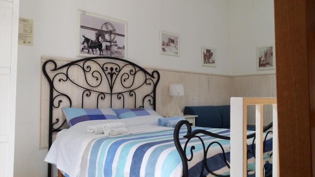 - une chambre dotée d'un grand lit avec des draps bleus et blancs dans l'établissement Vacanze al San Domenico, à Mola di Bari