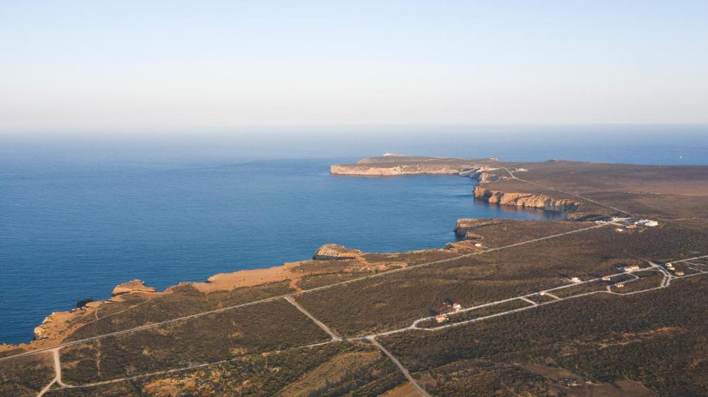 an aerial view of the ocean and a mountain at Aldeia Caiçara Surf House in Sagres