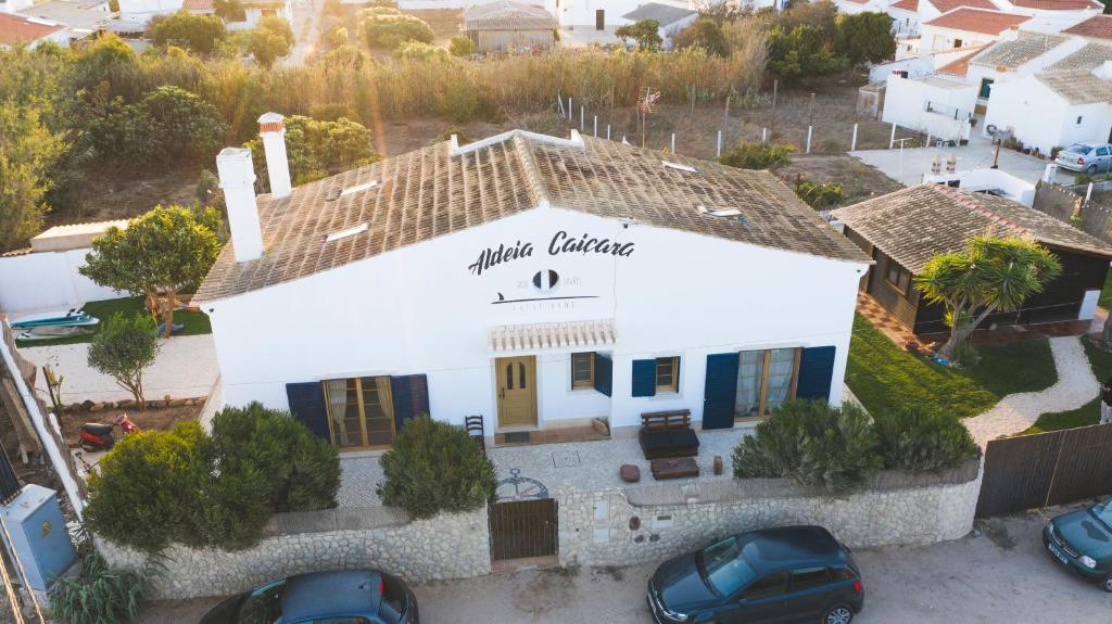 an aerial view of a white building with a sign on it at Aldeia Caiçara Surf House in Sagres