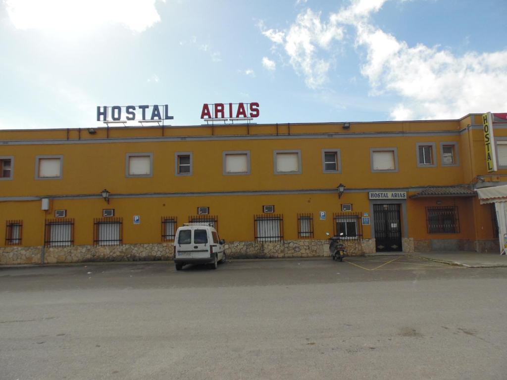 Hostal Arias في زافرا: مبنى اصفر مع لوحة مكتوب عليها اطلس المستشفى