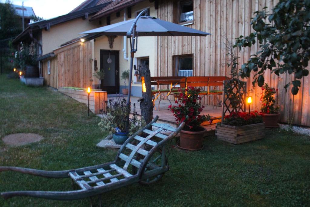 a bench in a yard with an umbrella at AnNo- Ihre Wohlfühloase mit Garten in Klingenbrunn in Spiegelau