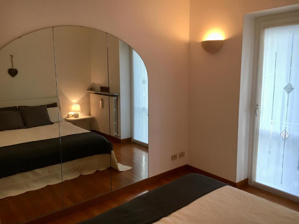 a bedroom with a large mirror and a bed at la casetta in Abbadia Lariana