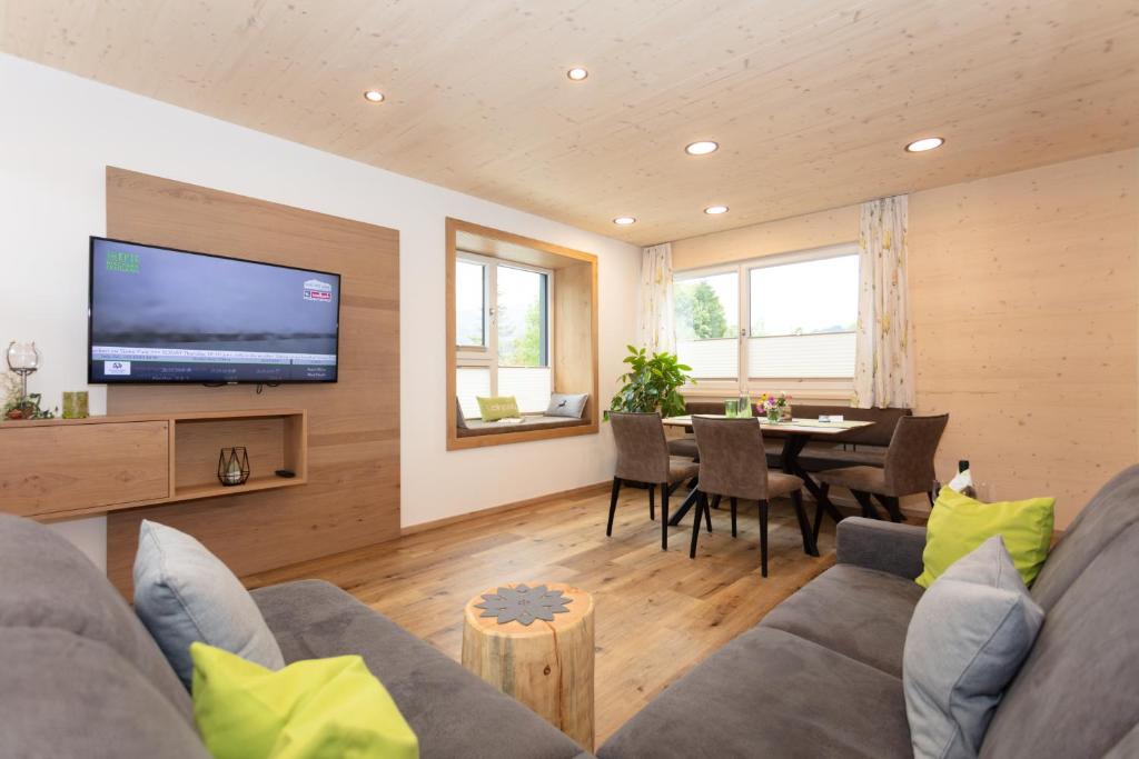 ein Wohnzimmer mit einem Sofa und einem Esszimmer in der Unterkunft Appartments Niedermoser in Leogang
