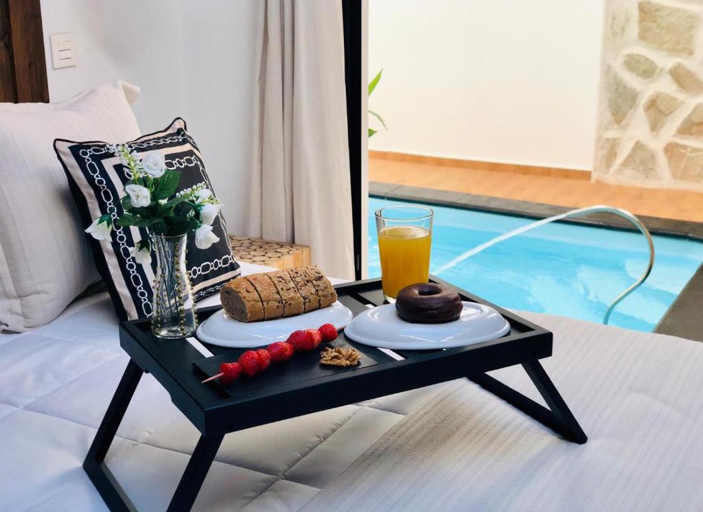 a coffee table with a tray of food and a glass of orange juice at Canaryislandshost l Nazaret Suites in Nazaret