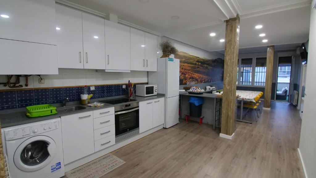 a kitchen with white cabinets and a washer and dryer at Duquesa 32 in Logroño