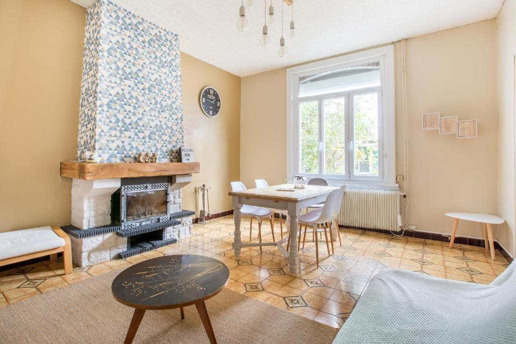 a living room with a table and a fireplace at Chez Charlotte in Angres