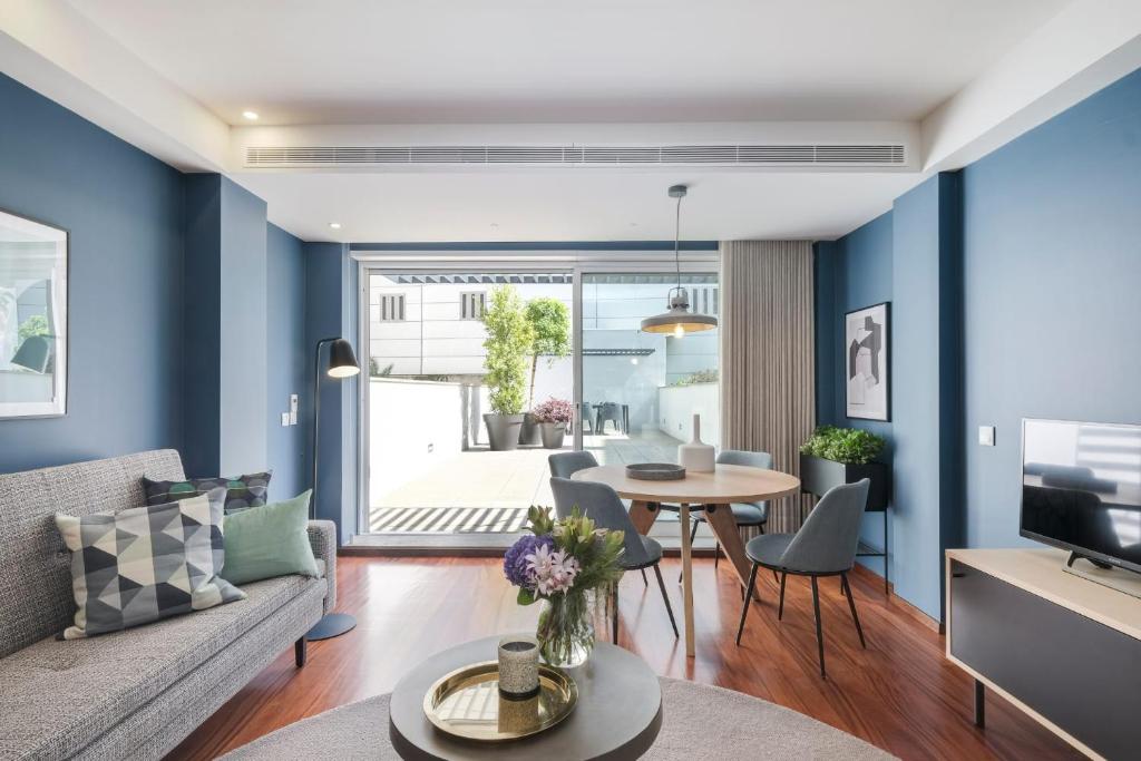 uma sala de estar com paredes azuis e uma mesa e cadeiras em Nº150 Apartment with terrace em Braga