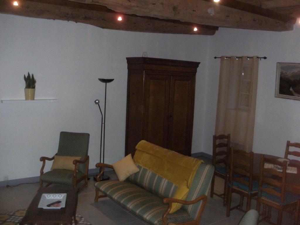 a living room with chairs and a couch and a table at grange dans ancien corps de ferme in Bellengreville