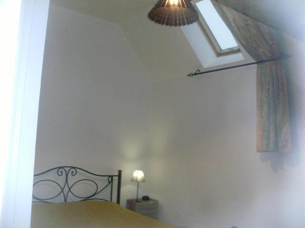 a bedroom with a bed and a skylight at grange dans ancien corps de ferme in Bellengreville