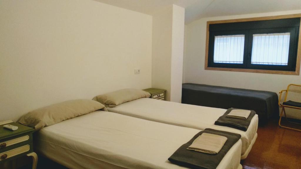 1 dormitorio con 2 camas y ventana en A Conserveira, en Redondela