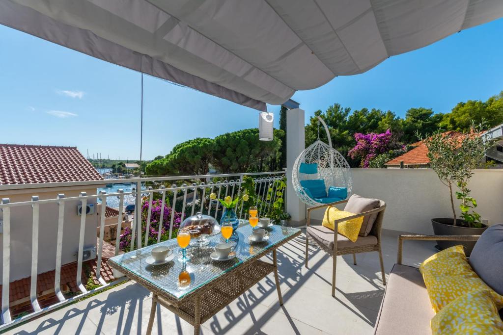 eine Terrasse mit einem Tisch und Stühlen auf dem Balkon in der Unterkunft Matanovi dvori in Milna