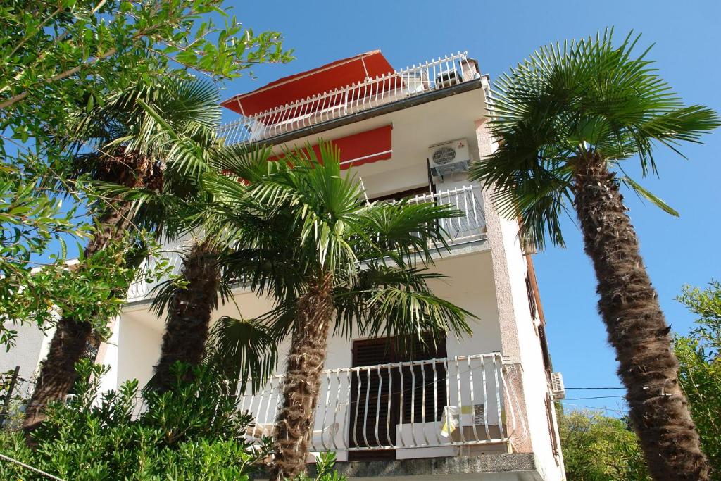 a building with palm trees in front of it at Apartments Stella in Selce