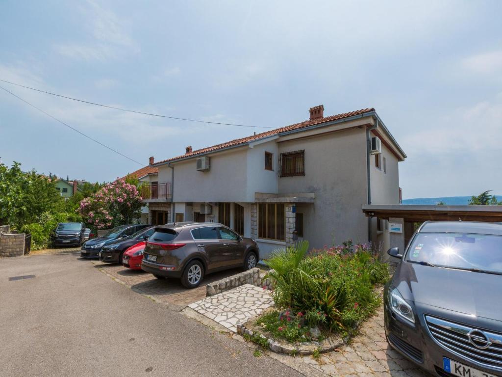 a group of cars parked in front of a house at Apartments Milica in Crikvenica