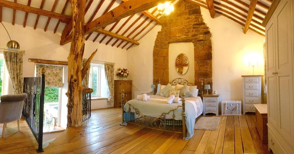 a bedroom with a bed in a room with wooden floors at The Tree House Cumbria in Beckermet
