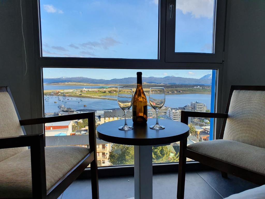 ウシュアイアにあるLiveUshuaia Beagle Viewのワイン1本、窓際のテーブルにグラス2杯