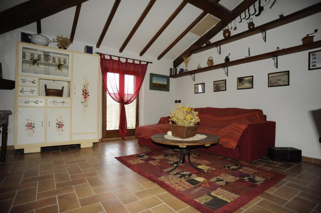 a living room with a red couch and a table at La Miniera in Montefollonico