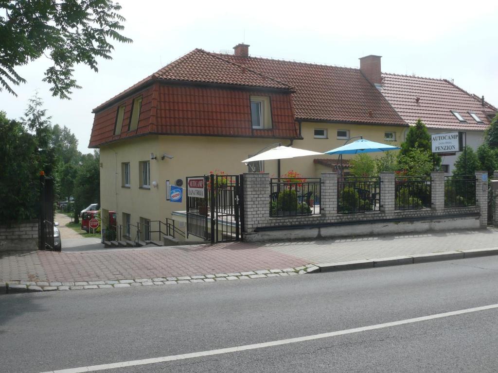 a house with a fence next to a street at Penzion Dana Troja in Prague