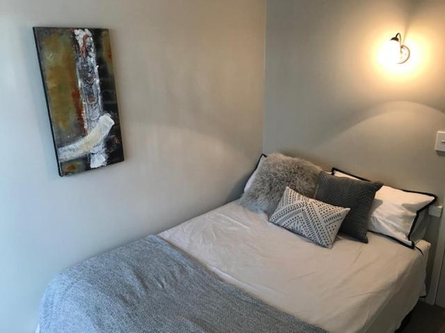 um quarto com uma cama com um quadro na parede em TAURANGA, Bay of Plenty em Tauranga