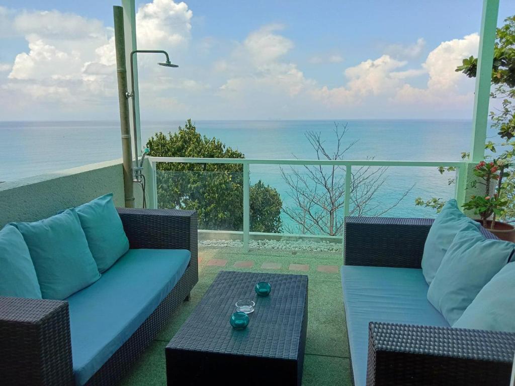 a patio with a couch and a table and the ocean at Penn Sunset Villa 7 in Ko Lanta