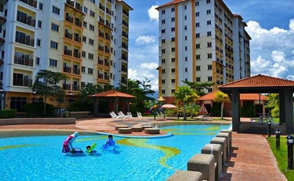 a swimming pool with children playing in the water at Suria Apartment 1BEDROOM Bukit Merah in Simpang Ampat Semanggol