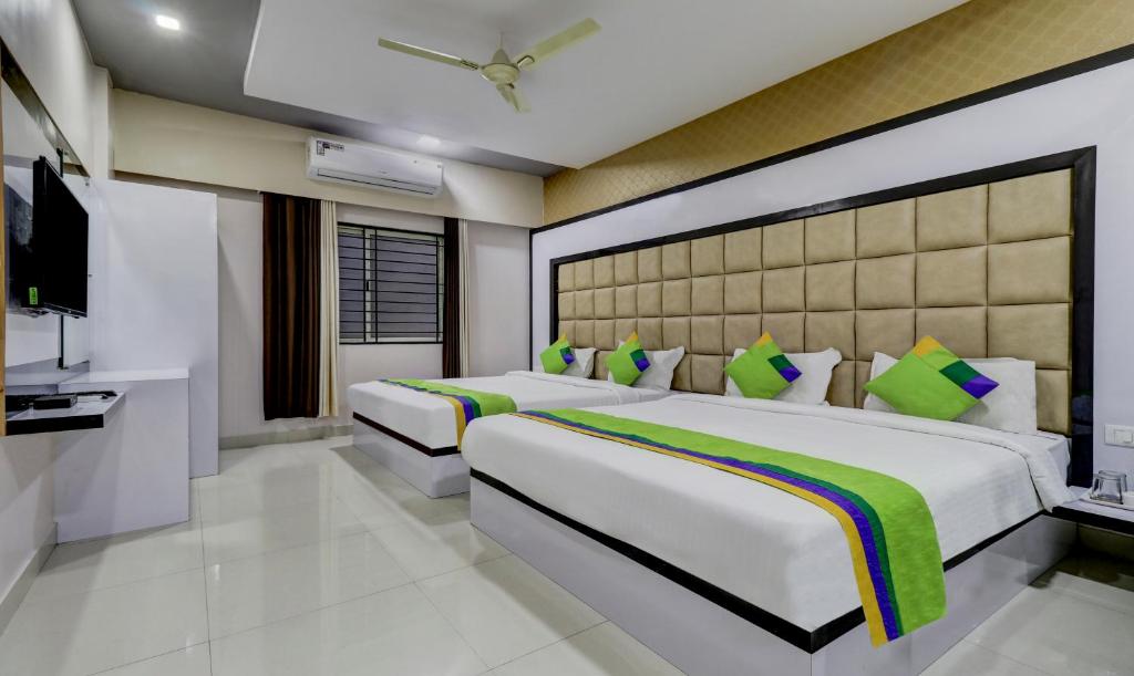 a bedroom with two beds and a flat screen tv at Treebo Trend Sahara Suites in Bangalore