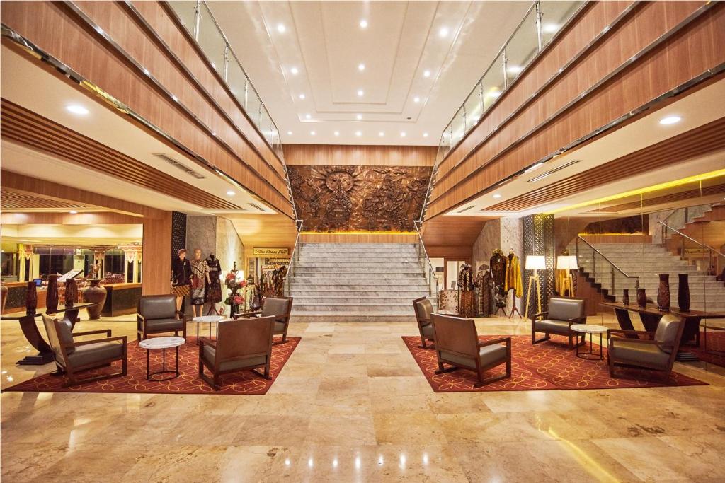 a lobby with chairs and stairs in a building at Patra Semarang Hotel & Convention in Semarang