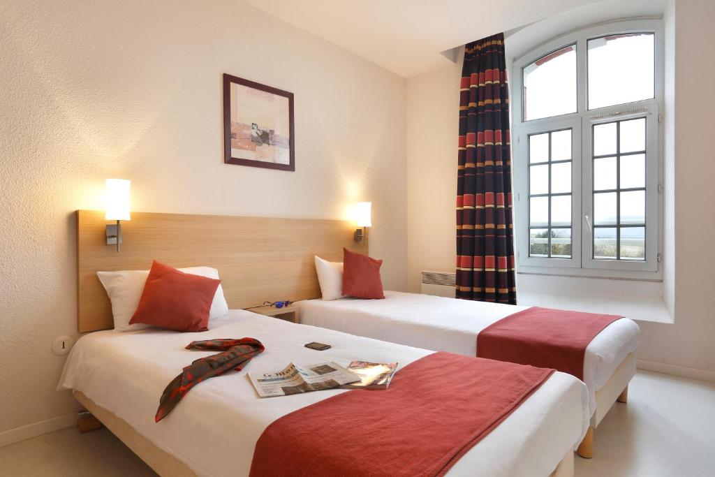 um quarto de hotel com duas camas e uma janela em Vacancéole - Les Demeures Champenoises em Épernay